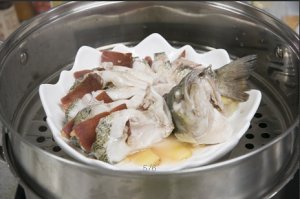 將鱸魚成花狀擺好，將火腿切片放入各縫隙中，放入鍋中隔水蒸12分鐘拿出，撒上蔥花即可。
