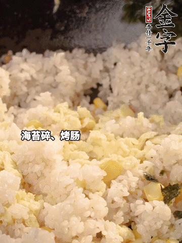 剩米飯下鍋炒散，依次下玉米粒、雞蛋、烤腸、海苔碎翻炒均勻。