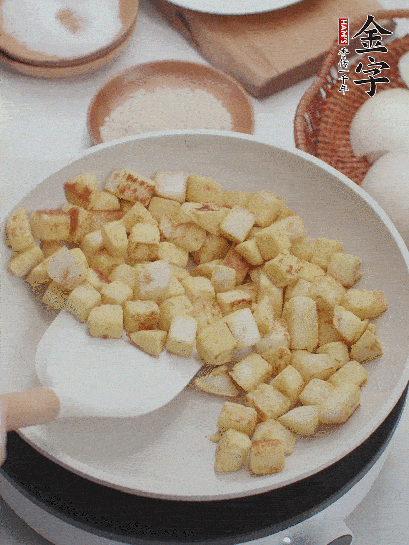 起鍋熱油，倒入饅頭丁，小火煎至蛋液凝固定型再翻面，饅頭丁部煎至金黃時盛起待用。