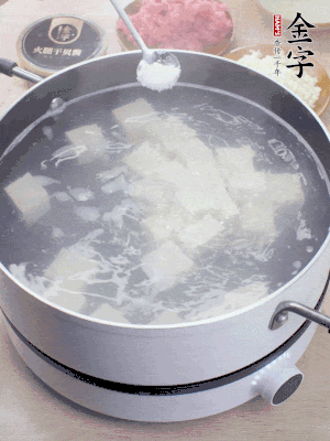 豆腐切成大小均勻正方體，鍋內(nèi)放水，加一點鹽焯水10秒。