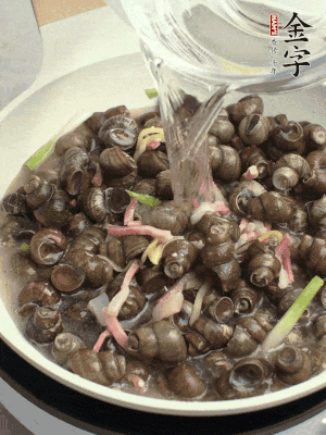 倒處理干凈的螺螄翻炒，加3勺料酒。加清水蓋過螺螄，中火蓋蓋煮5分鐘。