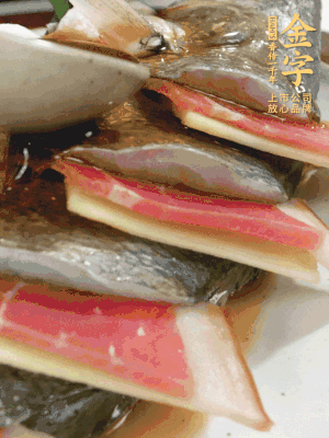 魚肚中塞蔥結、火腿片，魚身上碼放姜片、火腿片，倒入混合的料汁。