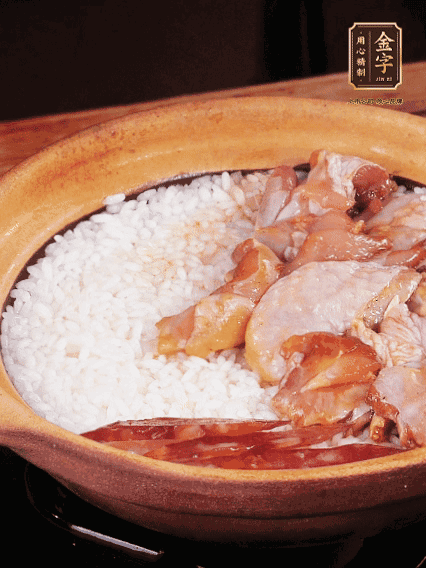 煮到椰子水微微收干轉(zhuǎn)小火，快速均勻鋪上雞肉、金字香腸