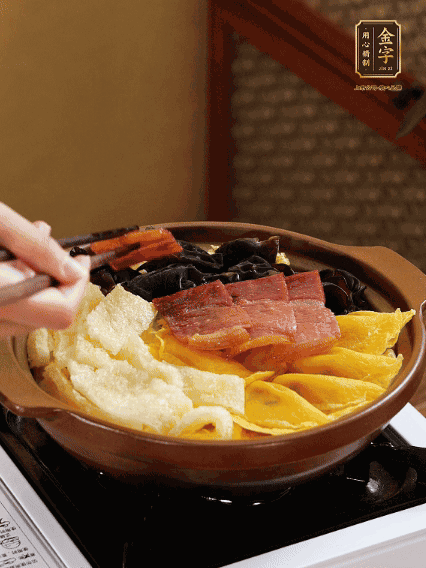 砂鍋底部鋪上娃娃菜，依次擺上肉皮、蛋餃、黑木耳、火腿